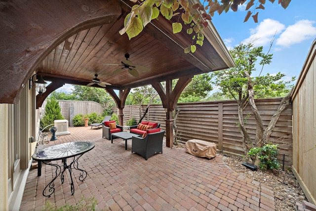view of patio / terrace with an outdoor living space, a ceiling fan, and a fenced backyard