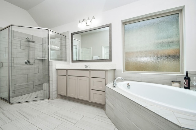 full bath featuring vanity, a stall shower, a garden tub, and lofted ceiling