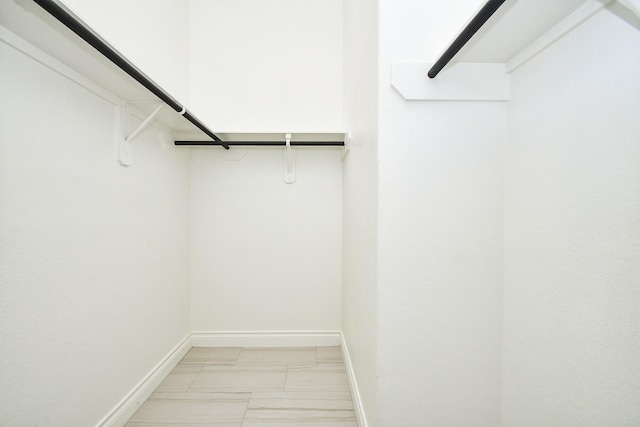 spacious closet featuring marble finish floor