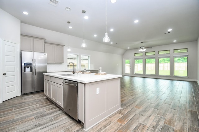kitchen with ceiling fan, visible vents, a sink, open floor plan, and stainless steel appliances
