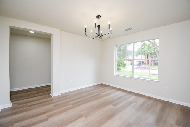 unfurnished dining area featuring baseboards, visible vents, an inviting chandelier, and light wood-style flooring