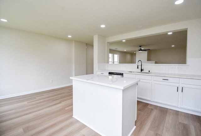 kitchen with decorative backsplash, a sink, and light wood-type flooring
