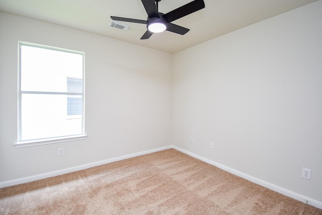 spare room with carpet floors, a ceiling fan, baseboards, and visible vents