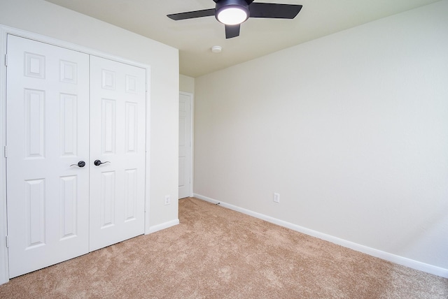 unfurnished bedroom featuring carpet floors, a ceiling fan, baseboards, and a closet
