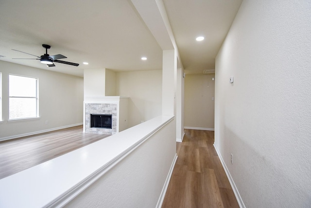 corridor featuring baseboards, recessed lighting, and wood finished floors
