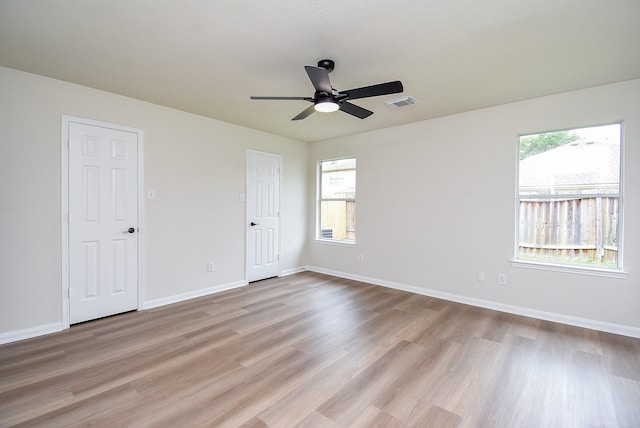 unfurnished room featuring baseboards, a ceiling fan, light wood-style flooring, and visible vents