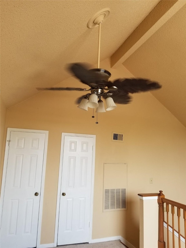 interior space featuring visible vents, a textured ceiling, and lofted ceiling