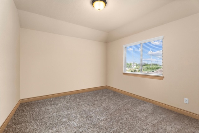 carpeted spare room featuring baseboards