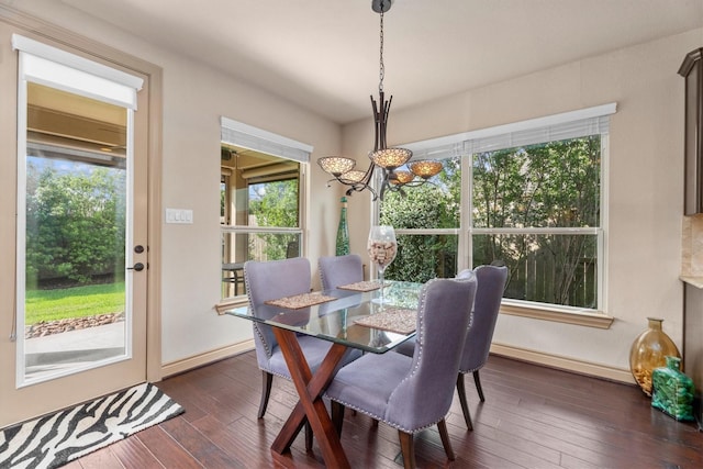 dining space featuring baseboards, a notable chandelier, and dark wood finished floors