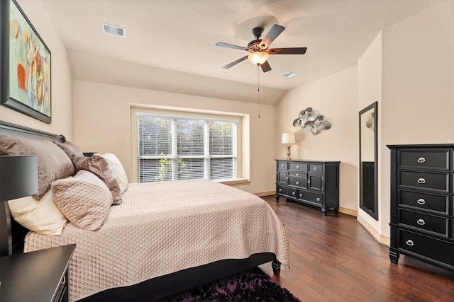 bedroom with a ceiling fan, dark wood-type flooring, lofted ceiling, and visible vents