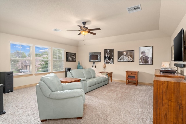 living area with visible vents, a ceiling fan, baseboards, and light colored carpet