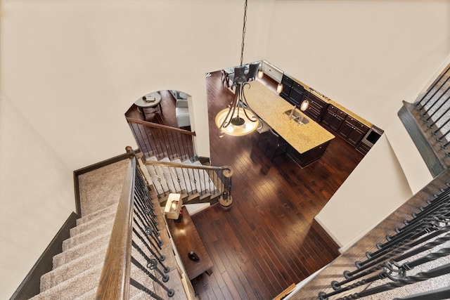 stairs with arched walkways, a high ceiling, and hardwood / wood-style floors