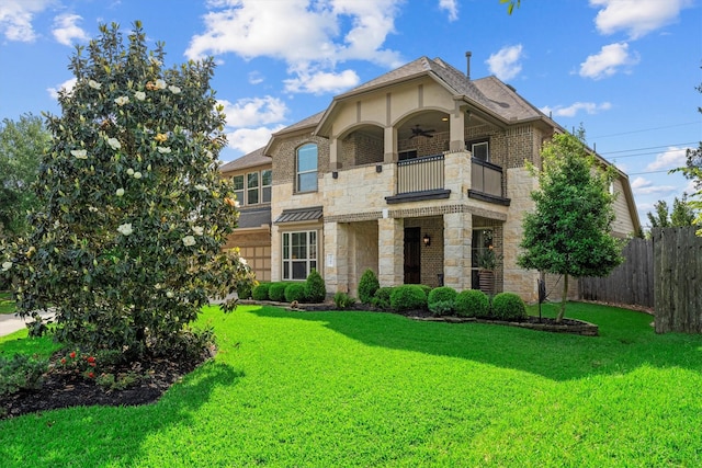 view of front of house featuring ceiling fan, fence, a balcony, and stone siding