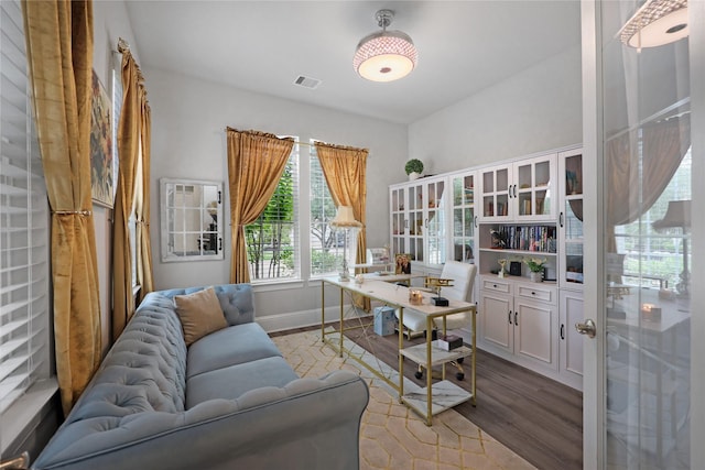 home office featuring baseboards, visible vents, and wood finished floors