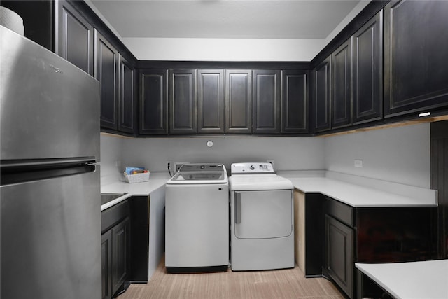 washroom featuring separate washer and dryer and cabinet space