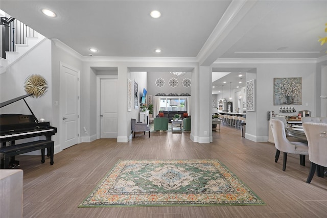 entryway featuring stairs, recessed lighting, baseboards, wood finished floors, and ornamental molding