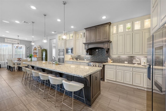 kitchen with recessed lighting, decorative backsplash, appliances with stainless steel finishes, and a kitchen breakfast bar