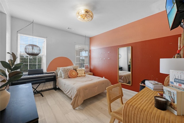 bedroom featuring wood finished floors and visible vents