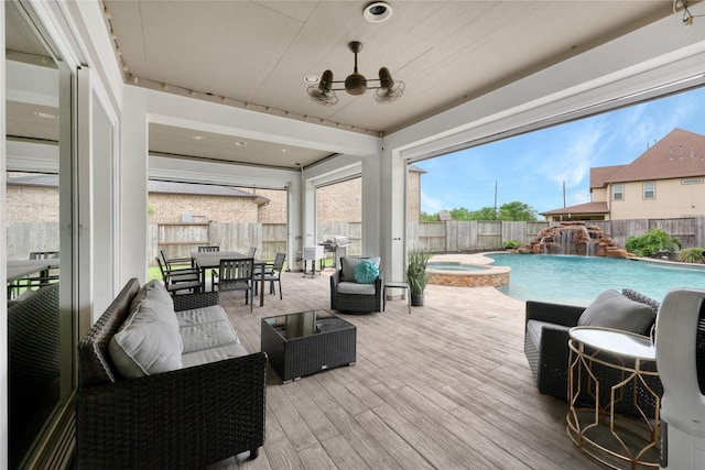 view of patio featuring a fenced backyard, a wooden deck, outdoor dining area, and a pool with connected hot tub