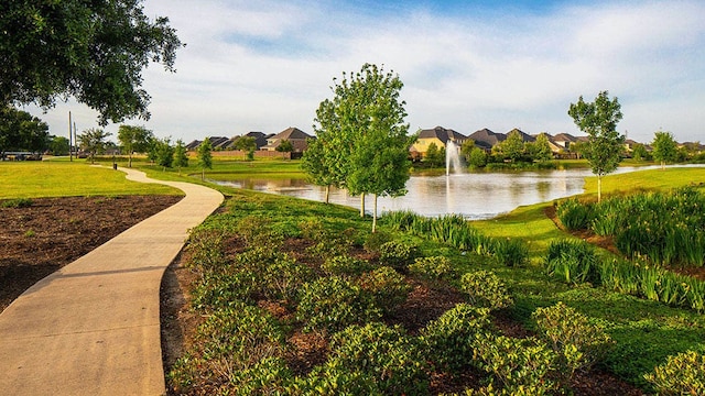 view of community featuring a lawn, a water view, and a residential view