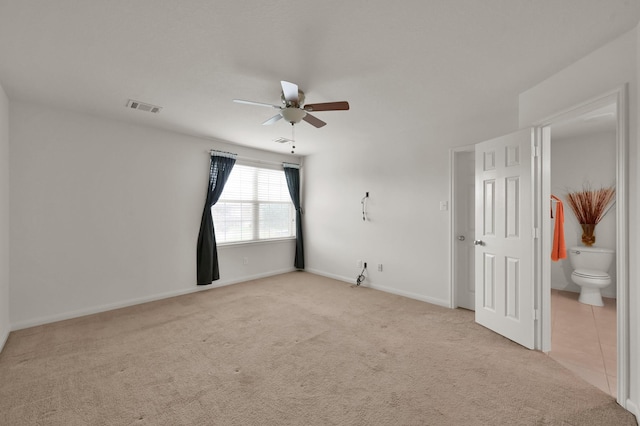 unfurnished bedroom with carpet, ensuite bath, a ceiling fan, and baseboards