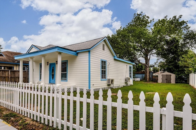 bungalow-style home with a porch, a front yard, a storage shed, a fenced backyard, and concrete driveway
