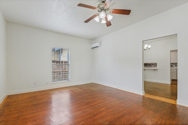 empty room featuring baseboards, a ceiling fan, a wall mounted air conditioner, and wood finished floors