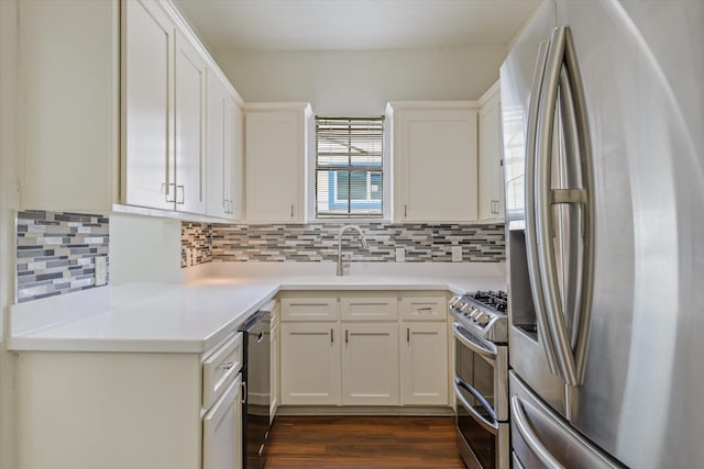 kitchen featuring dark wood-type flooring, a sink, decorative backsplash, and stainless steel appliances