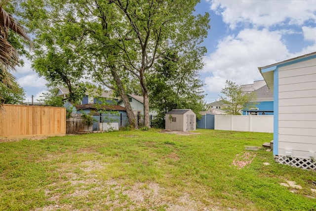 view of yard with a storage unit, a fenced backyard, and an outbuilding