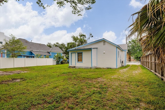 back of property featuring fence and a yard