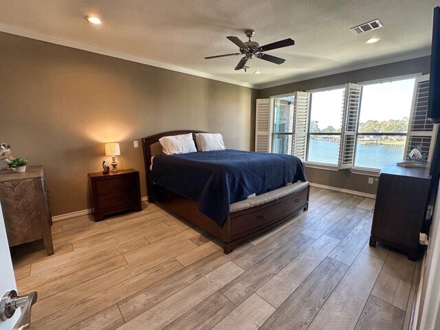 2112 Fm 3186 Unit 9, Onalaska, TX 77360 - bedroom featuring light wood-type flooring, ornamental molding, baseboards, a ceiling fan, and a textured ceiling