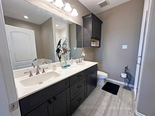 2112 Fm 3186 Unit 9, Onalaska, TX 77360 - full bath with baseboards, toilet, double vanity, a shower with shower door, and wood finished floors