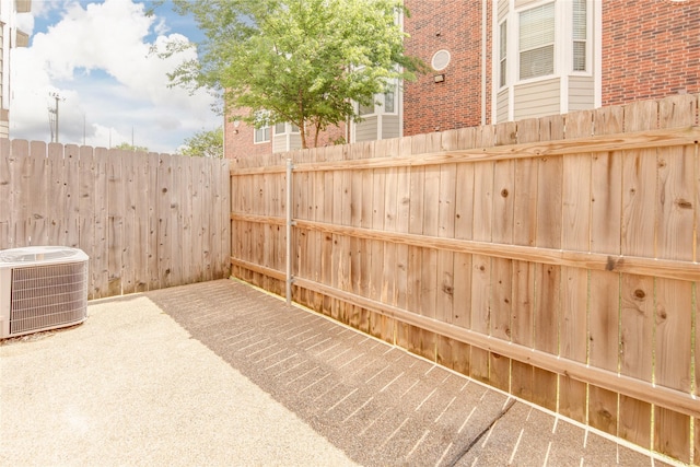 view of patio featuring central AC unit and fence