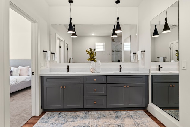881 Rachel St Unit F, Houston, TX 77091 - full bathroom featuring double vanity, a sink, wood finished floors, and a shower stall