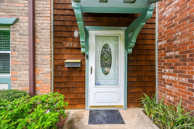 view of exterior entry featuring brick siding