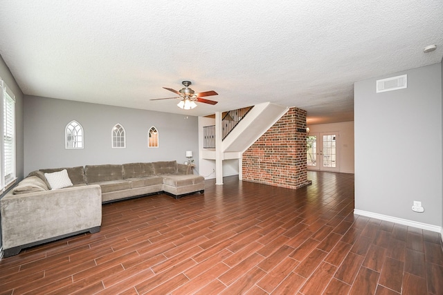 unfurnished living room featuring a ceiling fan, a textured ceiling, visible vents, and wood finished floors