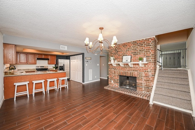 living room featuring a chandelier, baseboards, visible vents, and dark wood-style floors