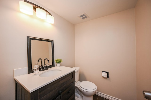 bathroom featuring vanity, baseboards, visible vents, and toilet