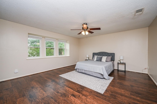 bedroom with a ceiling fan, baseboards, visible vents, and wood finished floors