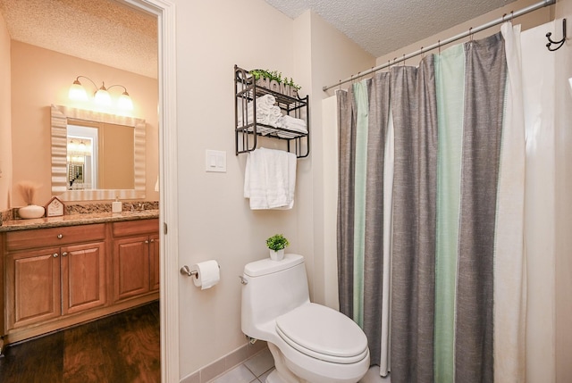 bathroom with a textured ceiling, vanity, baseboards, toilet, and a shower with shower curtain