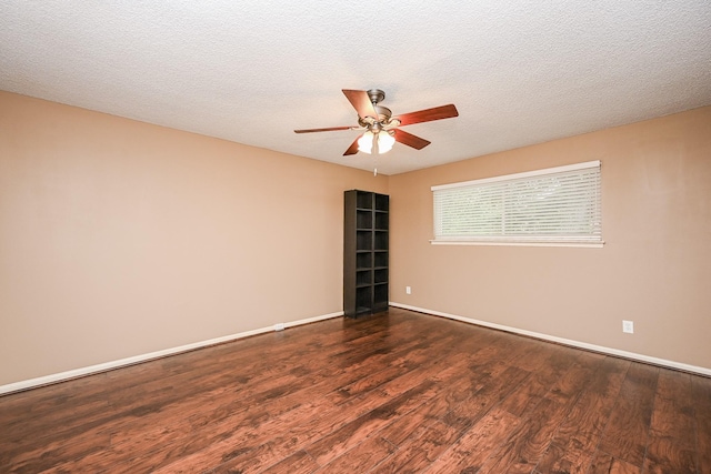 unfurnished room featuring baseboards, a ceiling fan, dark wood finished floors, and a textured ceiling