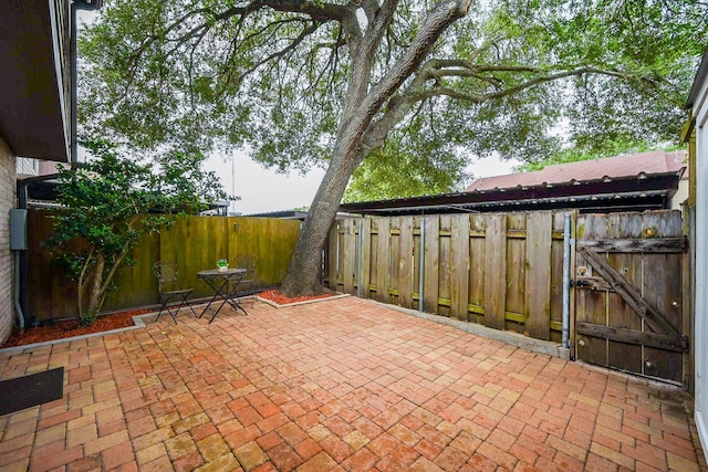 view of patio featuring fence and a gate