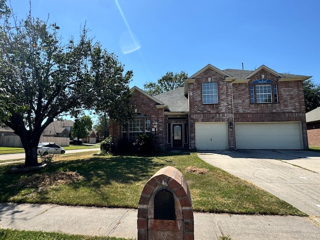 traditional home with brick siding, a garage, a front lawn, and driveway