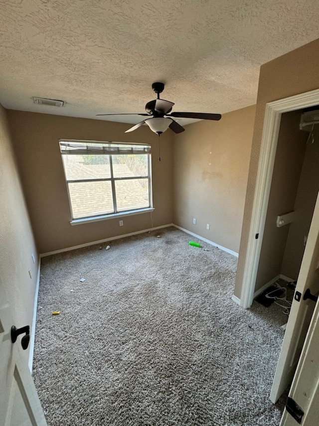 unfurnished bedroom with visible vents, baseboards, ceiling fan, a textured ceiling, and carpet