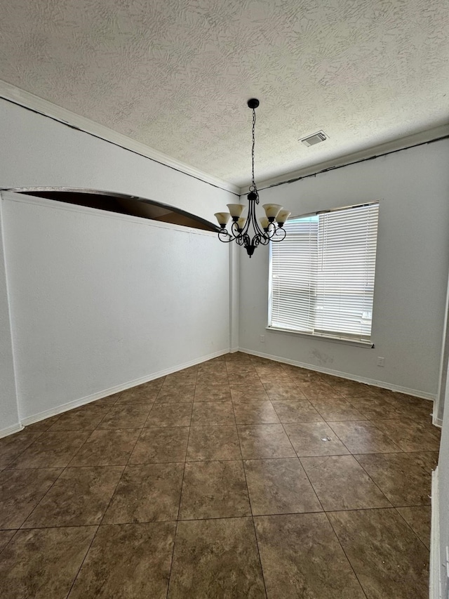 unfurnished dining area with an inviting chandelier, dark tile patterned flooring, a textured ceiling, and visible vents