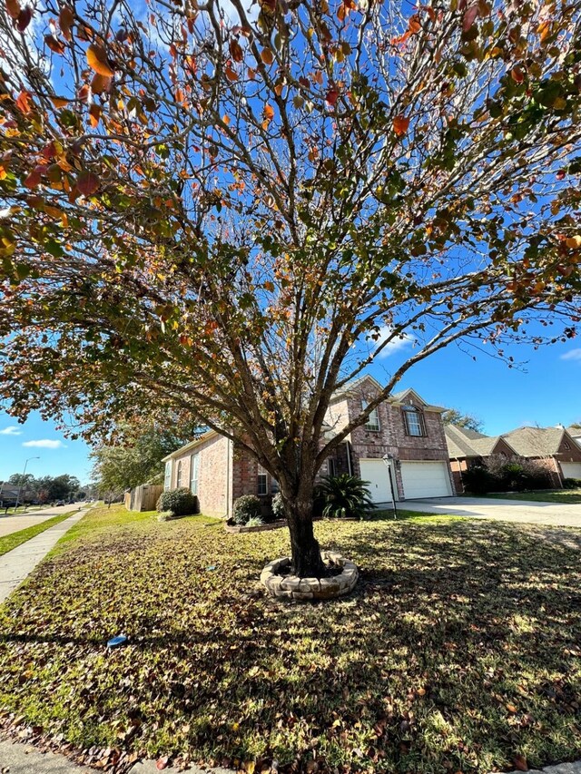 view of front of home with an attached garage, driveway, and a front lawn