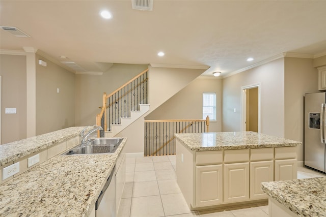 kitchen with stainless steel fridge, a sink, dishwasher, a center island, and visible vents