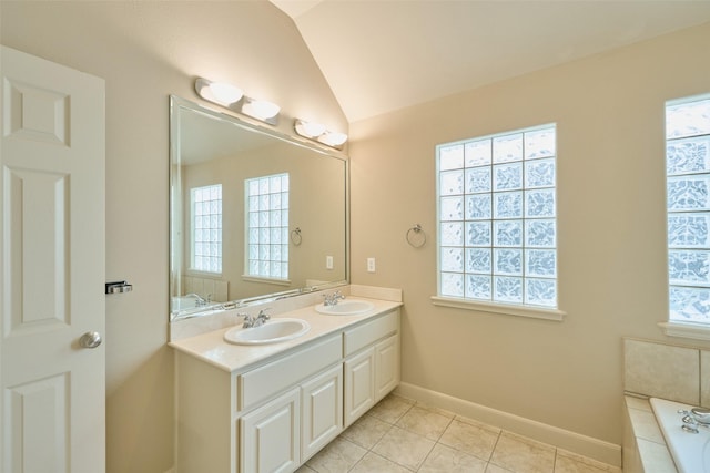 bathroom with a sink, vaulted ceiling, and a healthy amount of sunlight