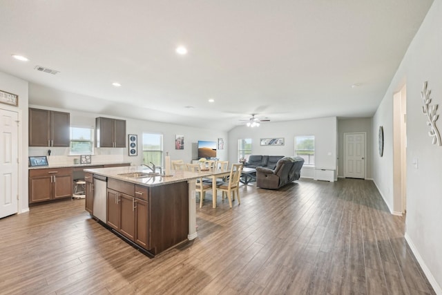 kitchen with a sink, dark wood finished floors, open floor plan, and dishwasher