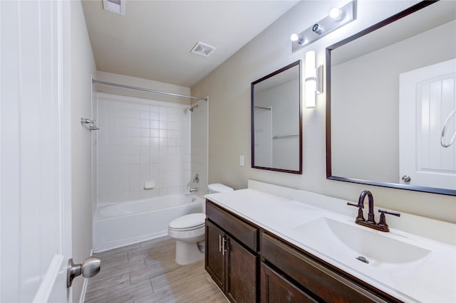 full bathroom featuring toilet, visible vents, tub / shower combination, and vanity